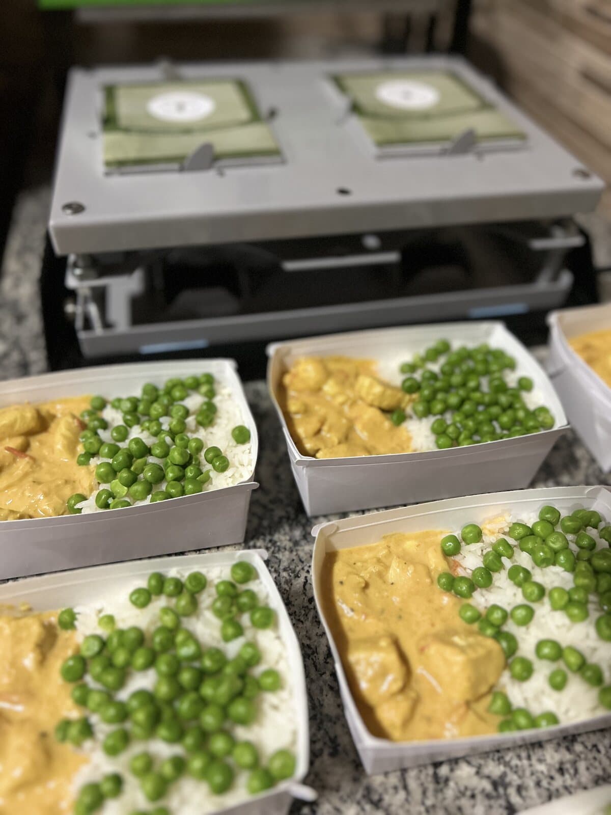 Marmitas alinhadas na seladora durante a produção